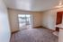 Bright, open living space featuring plush carpeting and access to a private balcony with picturesque views.