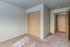 Bright room with soft carpet flooring, a spacious wooden closet, and warm natural light streaming in.