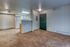Modern apartment interior showcasing an open-concept layout, with fresh carpet, a compact kitchen, and warm neutral tones.