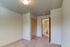 Inviting bedroom with neutral tones, cozy carpet, and ample closet space leading to a private bathroom.
