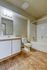 Modern bathroom with elegant tiling, sleek vanity, and a pristine bathtub, showcasing comfort and style.