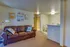 Cozy living space featuring a plush leather sofa, artistic wall decor, and an inviting dining nook with ambient lighting.