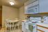 Cozy kitchen featuring a white round dining table with four chairs, an inviting space perfect for intimate meals.