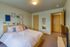 Cozy bedroom with stylish decor, featuring a comfortable bed adorned with plush pillows and creative wall art.