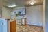 Bright and inviting kitchen with modern appliances, ample cabinetry, and stylish tile flooring in a chic apartment setting.