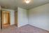 Inviting bedroom with soft carpet flooring, neutral walls, and ample closet space, perfect for creating a cozy personal retreat.