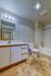 Modern bathroom with sleek vanity, bright lighting, and elegant tile flooring.