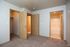 Inviting apartment interior with warm wooden doors, cozy carpeted flooring, and an en-suite bathroom for comfort and convenience.