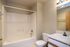 Modern bathroom with elegant bathtub, sleek vanity, and bright lighting, offering a serene and comfortable space.