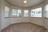 Bright and cozy corner room with large windows and lush carpet, offering a serene and sunlit space.