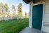 Charming outdoor view with lush green lawn and elegant white fencing next to a cozy home entrance.