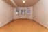 Bright and inviting room with warm wood flooring and ample natural light from large windows.