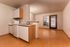Bright and inviting open-concept kitchen and living area with modern cabinetry and large windows.