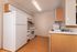 Modern kitchen with abundant cabinetry, sleek countertops, and a stylish white refrigerator and stove.