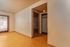 Bright and welcoming room with warm wood flooring, leading to a cozy closet space and room entrance.