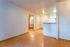 Inviting open-plan apartment interior with warm wooden flooring, elegant lighting, and cozy kitchen space.