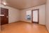 Bright and welcoming living area featuring warm wood flooring and a large window with natural light.