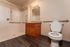Elegant and accessible bathroom with stylish wooden cabinetry, granite countertop, and sleek walk-in shower.