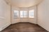 Bright and inviting corner nook with elegant wood flooring and abundant natural light from three large windows.