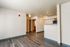 Modern apartment interior featuring elegant wood flooring, open living space, and a stylish kitchen with granite counters.