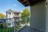 Charming balcony view showcasing a serene neighborhood with lush greenery and elegant homes.