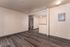 Inviting open concept living area featuring elegant wood flooring and abundant natural light, leading to a cozy kitchen space.
