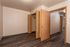 Inviting bedroom with warm wooden flooring and ample closet space, accentuated by natural light.