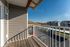 Charming balcony view featuring modern apartment buildings, a scenic hillside, and a clear blue sky, perfect for relaxation.