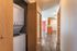 Inviting apartment hallway leading to a modern kitchen, featuring elegant wood flooring and a convenient in-unit washer and dryer.