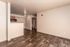 Modern open-plan living area with stylish wood flooring and natural light, offering a spacious and inviting atmosphere.