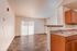 Bright open-concept living area with elegant wooden flooring and modern kitchen, perfect for cozy gatherings.