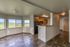Bright open-concept living space with modern kitchen, sleek flooring, and scenic views from multiple windows.