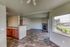 Modern open-concept living area featuring elegant wooden flooring, a cozy fireplace, and large windows offering abundant natural light and scenic views.
