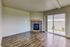 Inviting living room with modern fireplace, sleek hardwood flooring, and large sliding glass doors opening to a serene outdoor space.