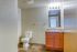 Bright and inviting bathroom featuring modern fixtures, sleek vanity with ample storage, and warm wood-inspired flooring.