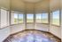 Bright room with panoramic windows showcasing stunning countryside views and elegant hardwood flooring.