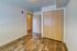 Modern bedroom with sleek wood flooring, ample closet space, and a minimalist design, perfect for comfortable living.