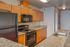 Contemporary kitchen with sleek granite countertops, modern black appliances, and elegant wooden cabinetry.