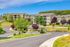 Charming apartment complex nestled in lush greenery with vibrant trees and scenic surroundings, offering a serene living experience.