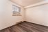 Bright and welcoming room with modern wood flooring and a large window letting in natural light, perfect for a cozy retreat.