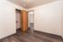 Cozy room with sleek wooden flooring, an open closet, and a warm ambient light, perfect for creating a personalized space.