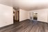 Bright and spacious living room with elegant wood flooring and large sliding doors opening to a scenic outdoor view.