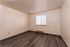 Bright room with elegant wood flooring, sleek baseboard heating, and large window filling the space with natural light.