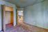 Inviting apartment interior showcasing a cozy carpeted room with built-in closet, seamlessly connected to a bright kitchen area.