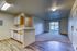 Spacious open-plan living area with modern kitchen, featuring sleek cabinetry and bright natural lighting through large sliding doors.
