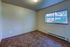 Cozy bedroom with plush carpet, neutral walls, and a large window showcasing scenic outdoor views.