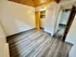 Charming room with sleek vinyl flooring, modern lighting, and a spacious closet in a cozy apartment.