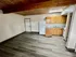 Charming apartment interior with modern wood panel ceiling, stylish laminate flooring, and a cozy kitchen featuring wooden cabinets and sleek counters.
