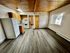 Charming open-plan kitchen with modern appliances, wooden cabinetry, and a warm wooden ceiling, complemented by sleek flooring and abundant natural light.