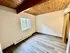 Charming apartment room featuring elegant wooden ceiling, large window with natural light, and modern flooring.